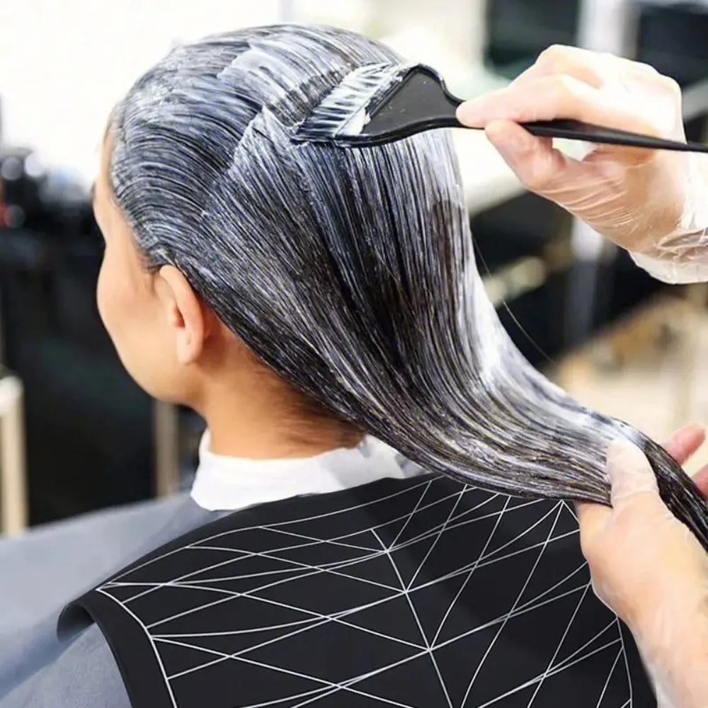 A person is using a reusable silicone hair dyeing cape and cutting collar to style their dark hair.