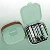 Kit de manucure vert clair avec couvercle articulé contenant des ciseaux et des coupe-cuticules en acier inoxydable.