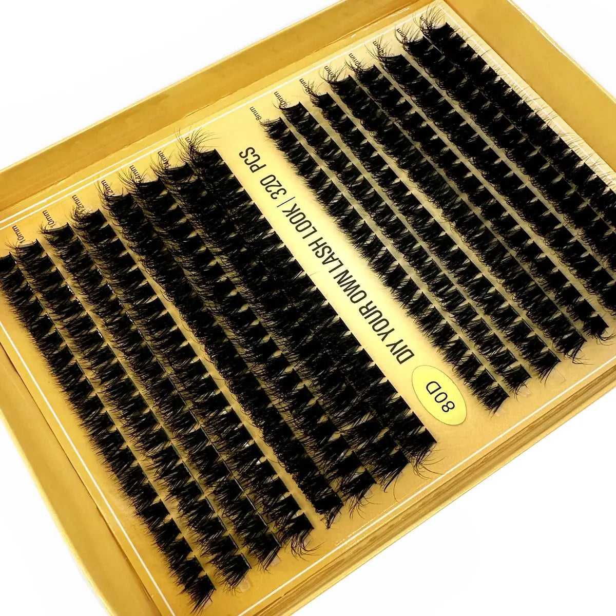 A gold box containing lash clusters for DIY eyelash extensions, featuring black mink-like lashes.