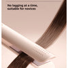 A close-up of a beige ceramic hair straightener and curler tool with dark brown hair being styled.