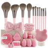 A collection of pink and gray makeup brushes, sponges, and applicators displayed on a wooden surface.