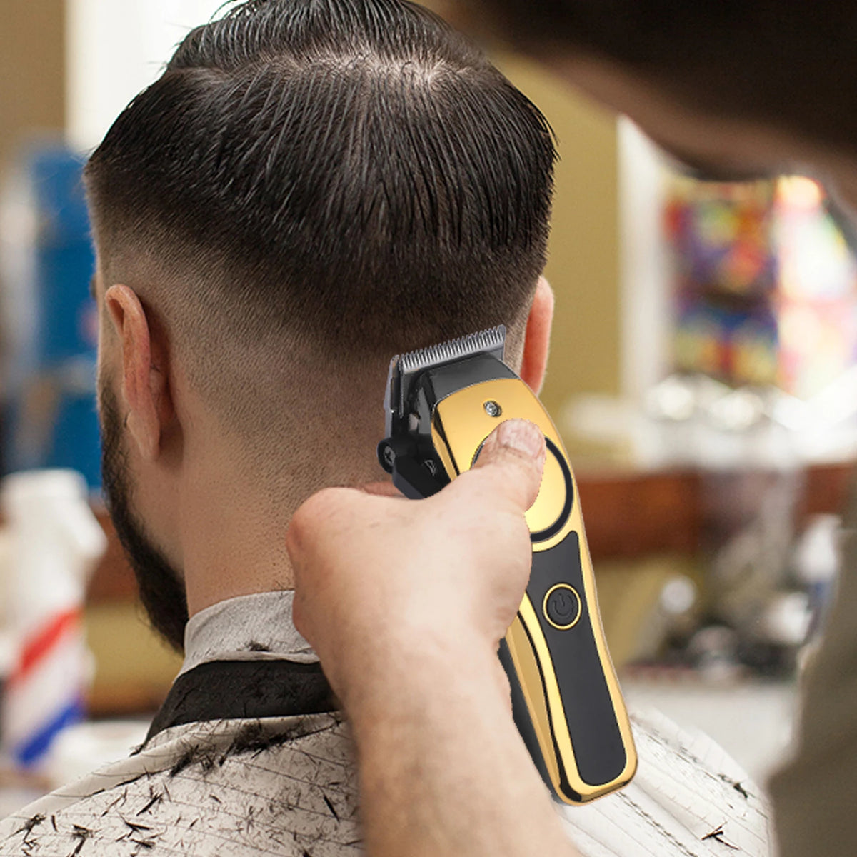 A person is using a gold-colored professional LCD hair clipper on the back of their head.