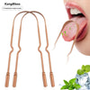 A pair of copper U-shaped tongue scrapers shown next to a person's mouth for oral hygiene.