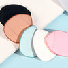 Un set de cinq mini éponges de fondation aux couleurs variées : noir, pêche, vert menthe, blanc et rose, posés sur un fond cl