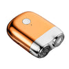 A close-up view of an orange and silver mini electric beard trimmer shaver.