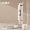 A beige portable electric body hair trimmer standing on a white base with a grooming tray.