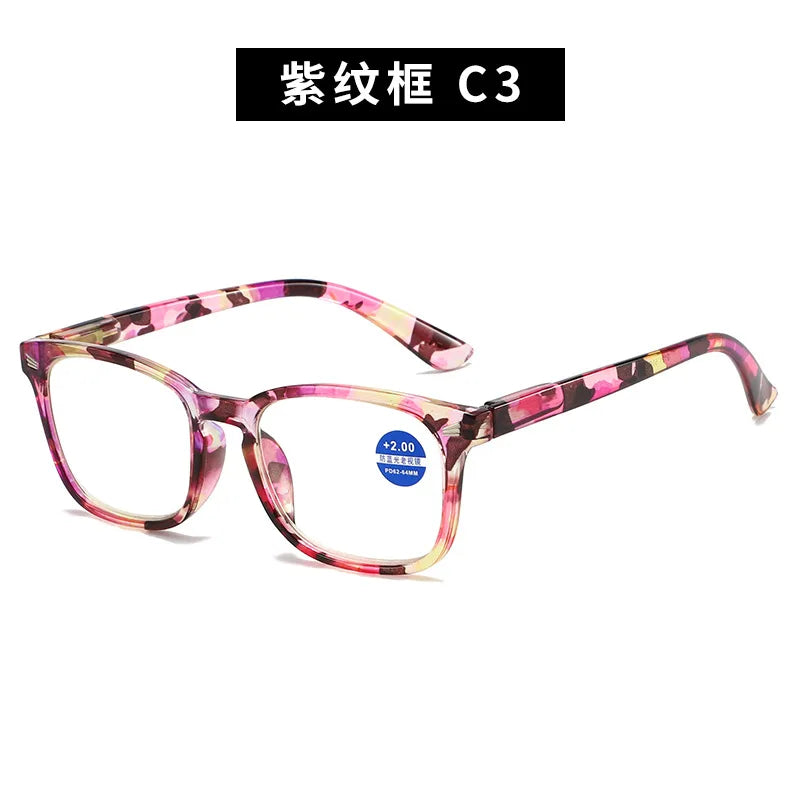 A pair of pink and purple patterned magnifying reading glasses.
