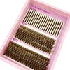 Une boîte rose contenant diverses extensions de faux cils naturels et fins de différentes longueurs et couleurs.