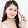 A woman holds a precision electric eyebrow trimmer in her hand against a white background.