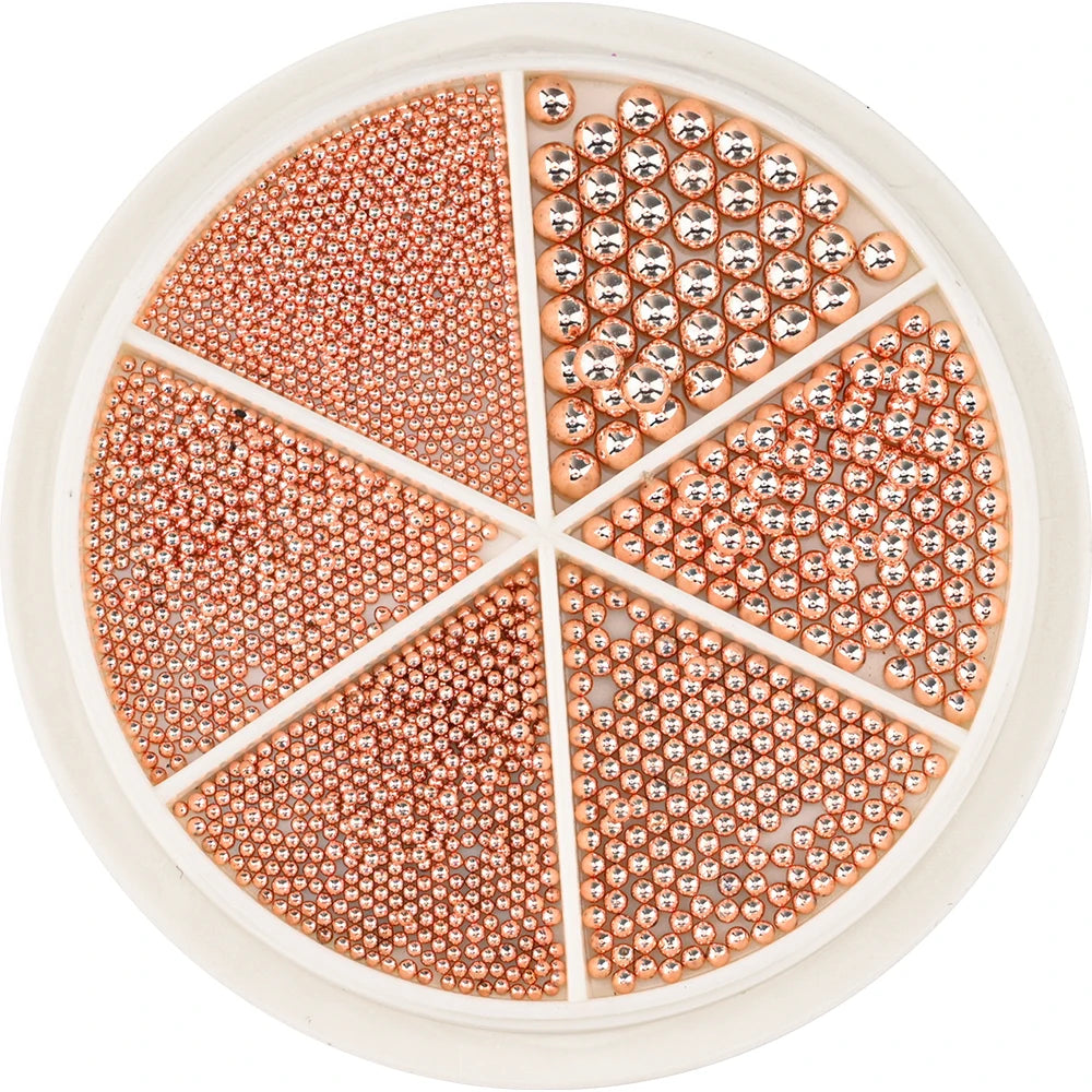 A circular tray of gold mixed stainless steel beads used for nail art decorations, divided into sections.