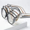 Un ensemble de lunettes de lecture style œil de chat de luxe avec diverses montures en métal et acétate, présentées sur une s