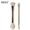 A pair of beige makeup brushes with natural hair bristles and gold-toned handles.