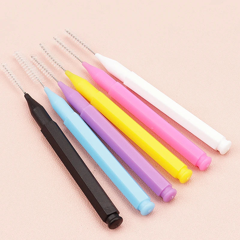 A set of precision eyebrow and lash brushes in various colors including black, blue, purple, yellow, pink, and white.