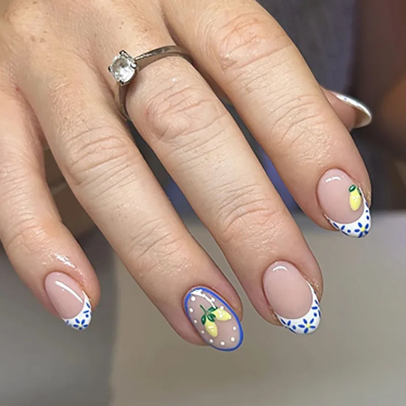 Une main montrant des kits de vernis à poser en forme de fleur d'amande avec des motifs floraux jaunes et bleus.