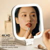 A woman is using a 4K HD LED makeup mirror to examine her skin and makeup.