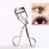 A silver professional eyelash curler tool shown with a close-up of curled eyelashes.