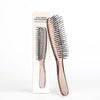 A wooden scalp brush for professional hair detangling shown next to its packaging.