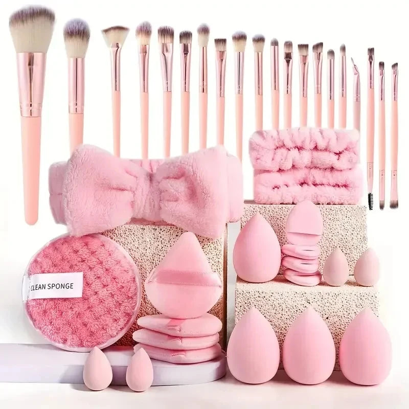 A collection of pink beauty sponges and applicators arranged on a white surface.