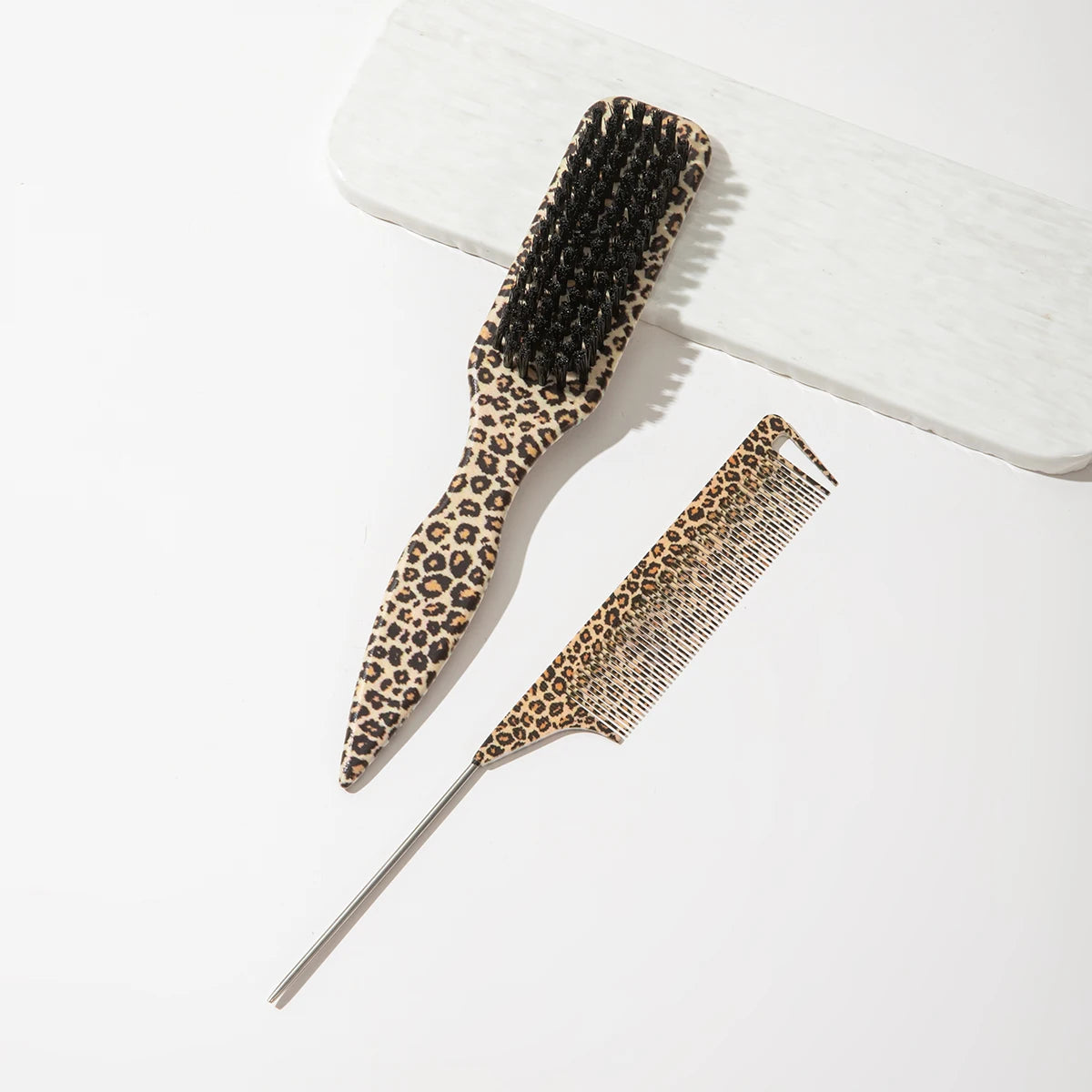 A set of two leopard print pointed tail hair combs displayed on a white surface.