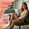 A woman is sitting on a couch holding a pink hair removal wax melting set.