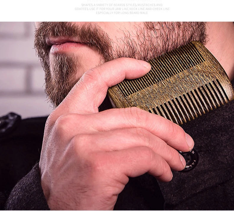 A hand is using a gold boar bristle beard and mustache comb on a man's face.