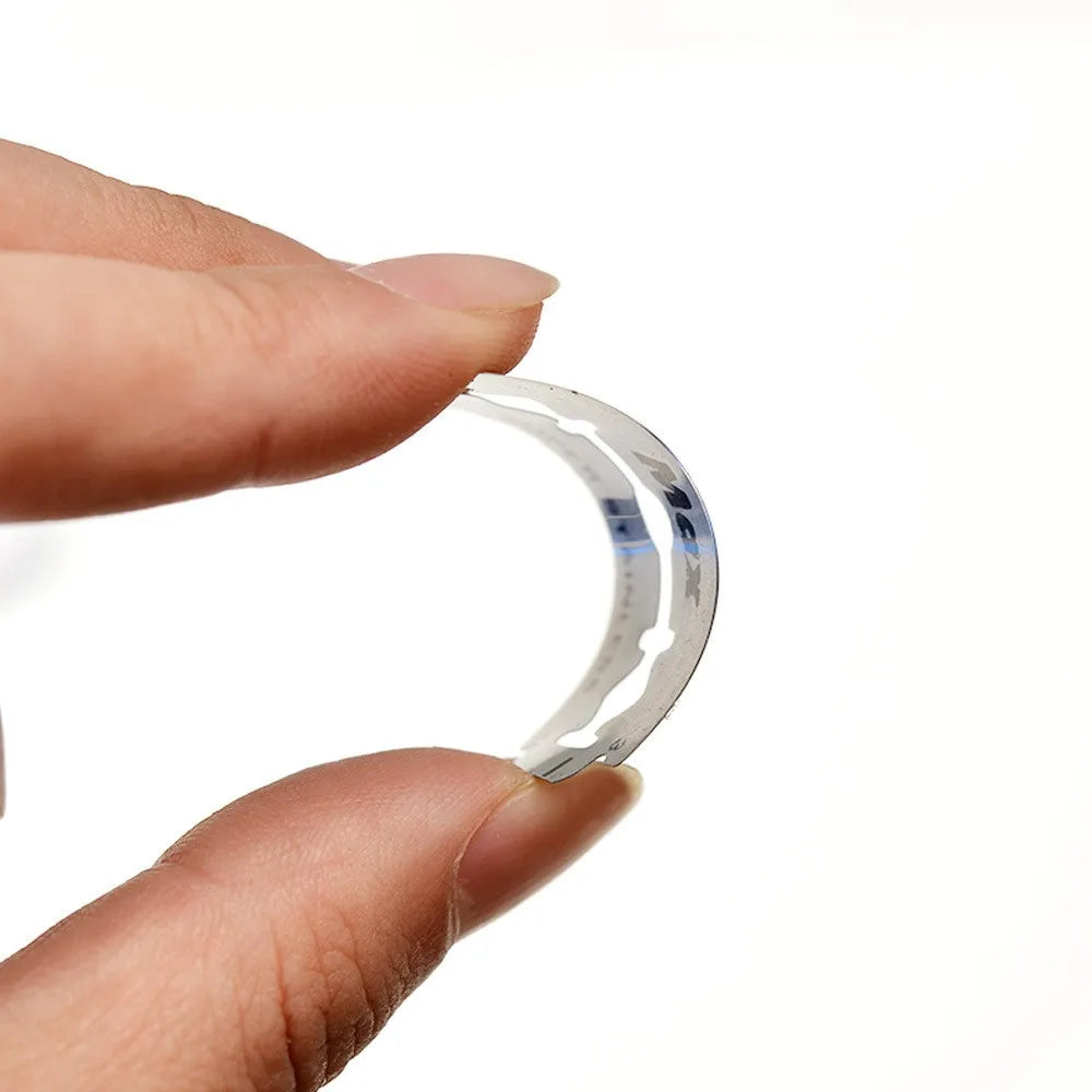 A hand holds a double-sided safety stainless steel razor, showing its curved blade design.