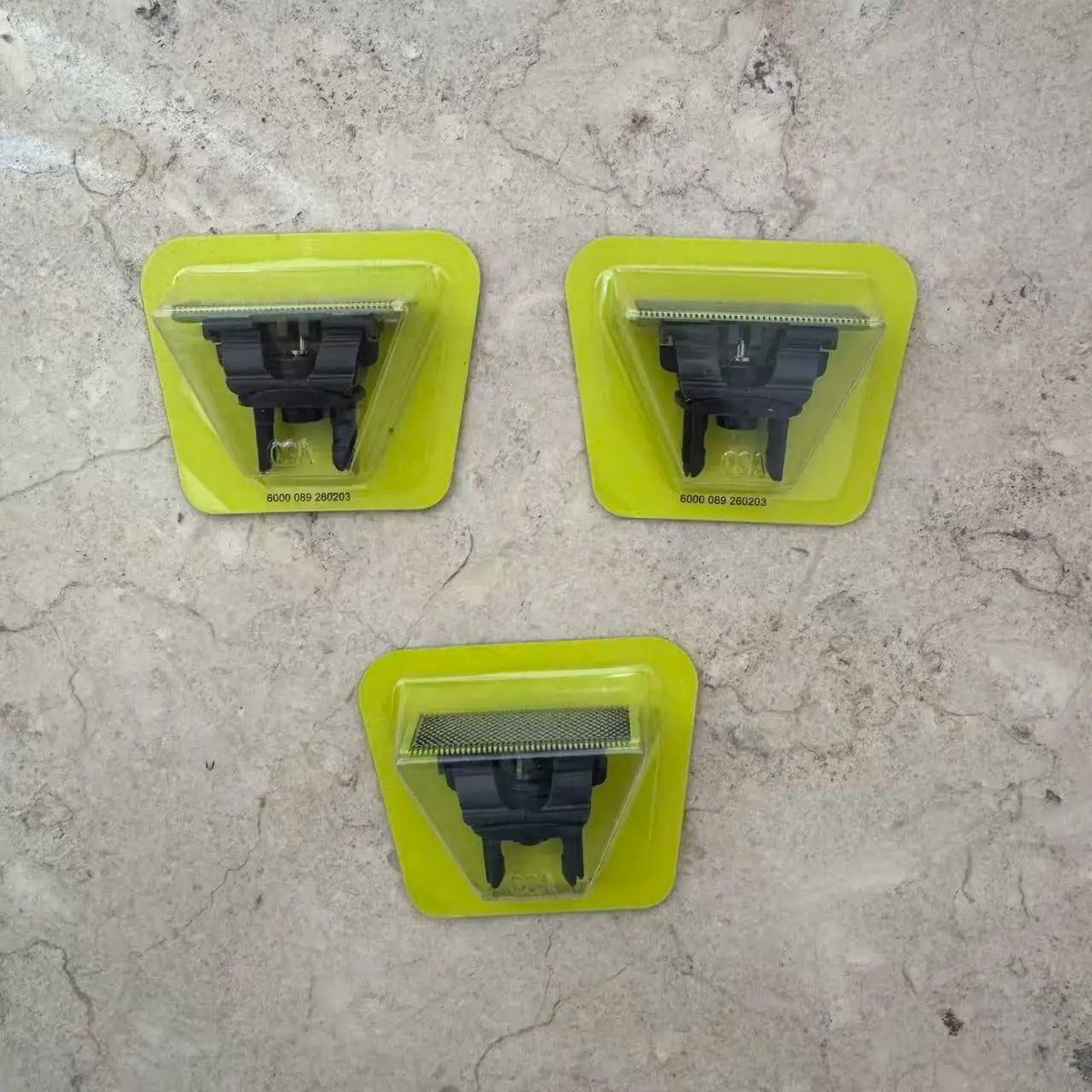 Three yellow plastic covers for a precision electric beard trimmer with black trimming attachments.
