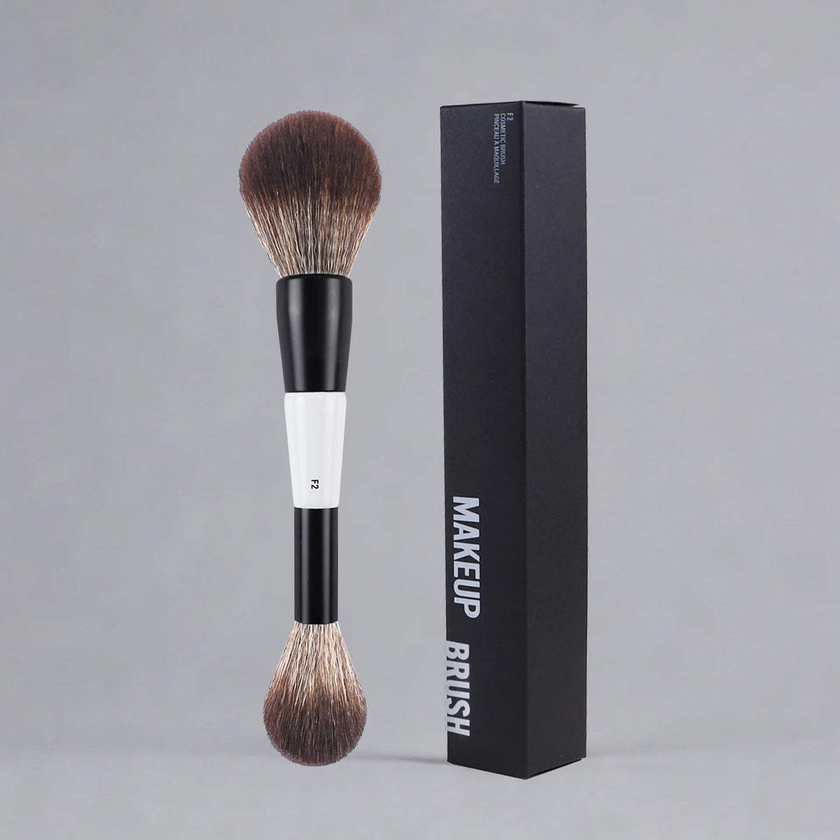 A black box containing a dual-ended makeup brush with a brown bristles and white handle.