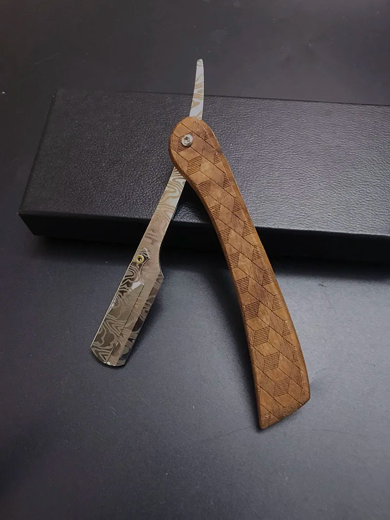 Afeita profesional manual de madera con cuchilla de color claro, exhibida sobre una superficie oscura.