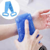 A hand is using a blue silicone body scrubber back brush on its skin for massage or cleaning.