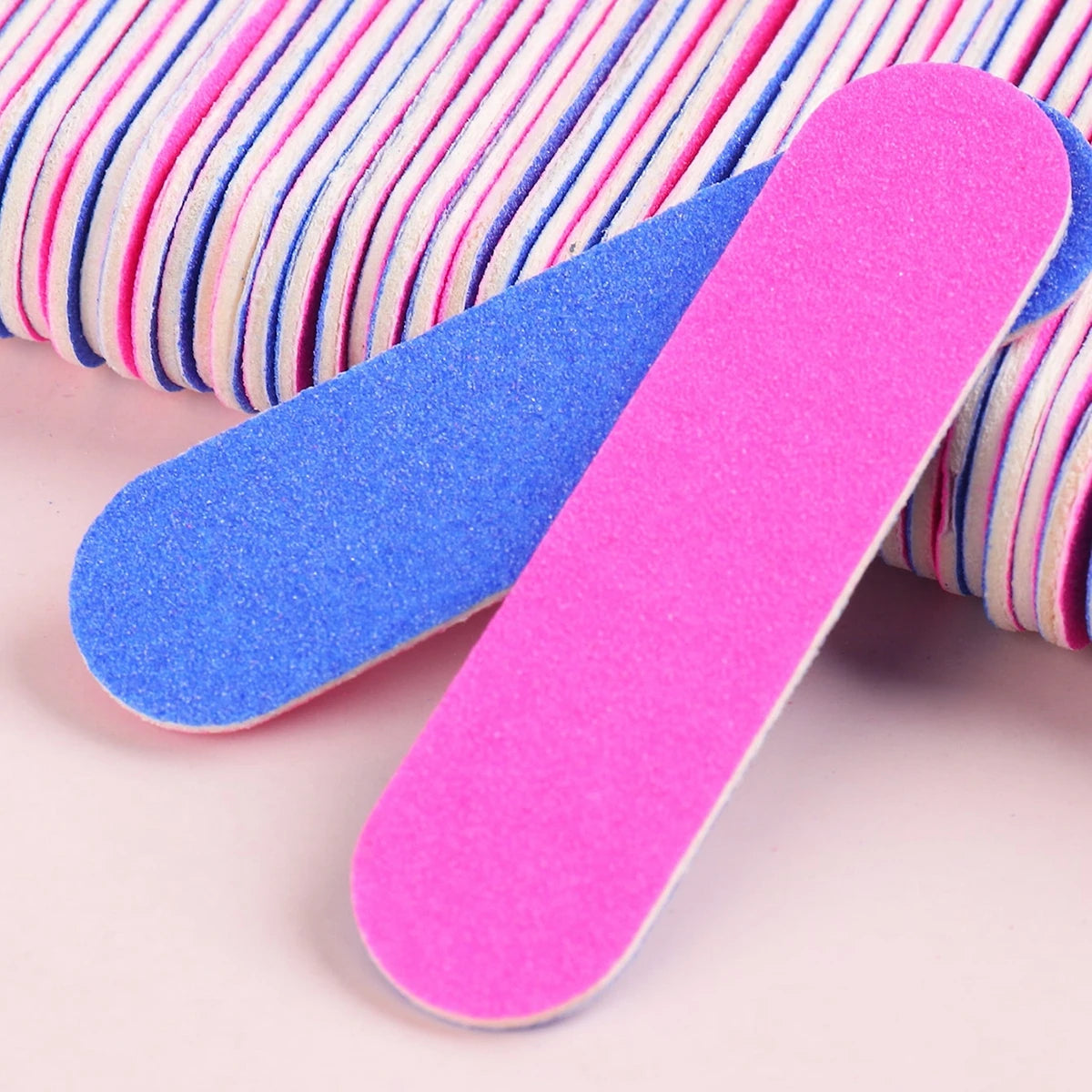 Two brightly colored double-sided mini nail files, one blue and one pink, are shown against a white background.