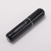 A sleek, black portable refillable perfume bottle with a silver band on the body.