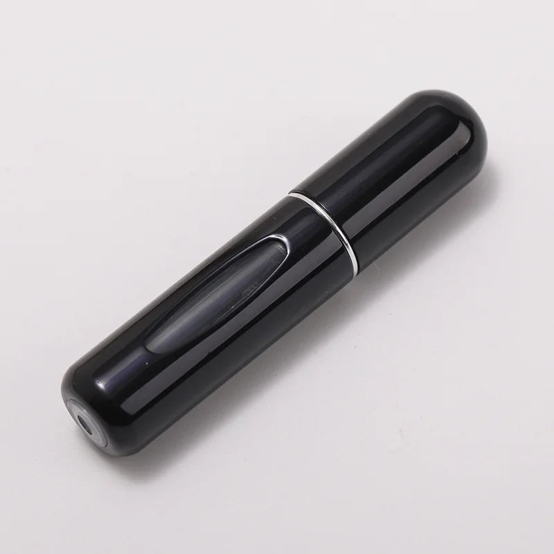 A sleek, black portable refillable perfume bottle with a silver band on the body.