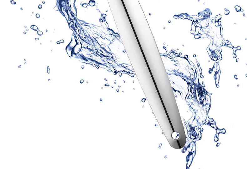 A stainless steel tongue scraper is shown with water splashing around it against a white background.