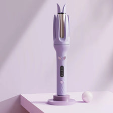 A purple automatic ceramic hair curler with a metallic nozzle is displayed on a white surface.