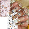 A hand displays various flower and butterfly nail stickers for DIY decoration on a fingernail.