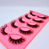Un plateau en plastique rose contenant cinq paires de faux cils dramatiques.