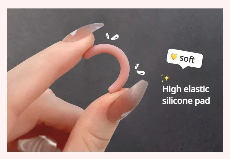 Gros plan d'une main utilisant un coussinet en silicone souple pour recourber une cil.