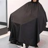 Une cape professionnelle noire pour couper les cheveux, drapée sur un mannequin.