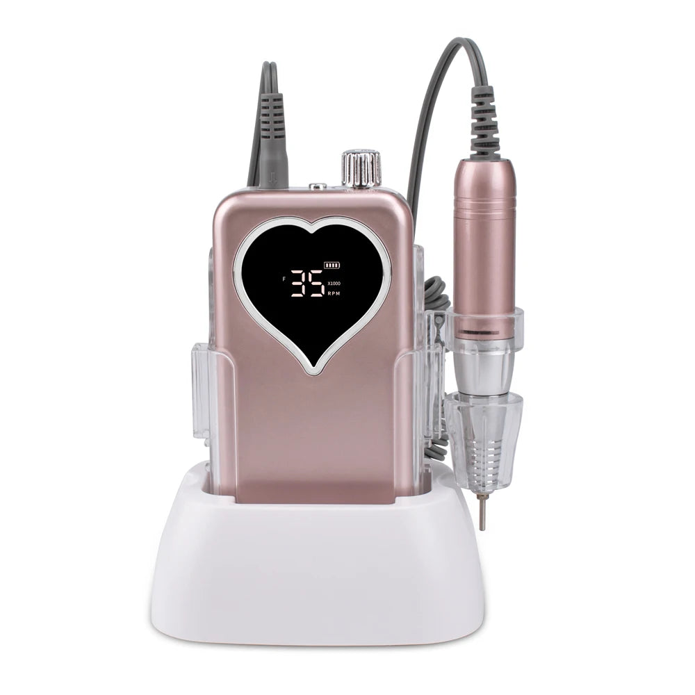 A pink cordless rechargeable nail drill device with a heart-shaped display and attached power cord.