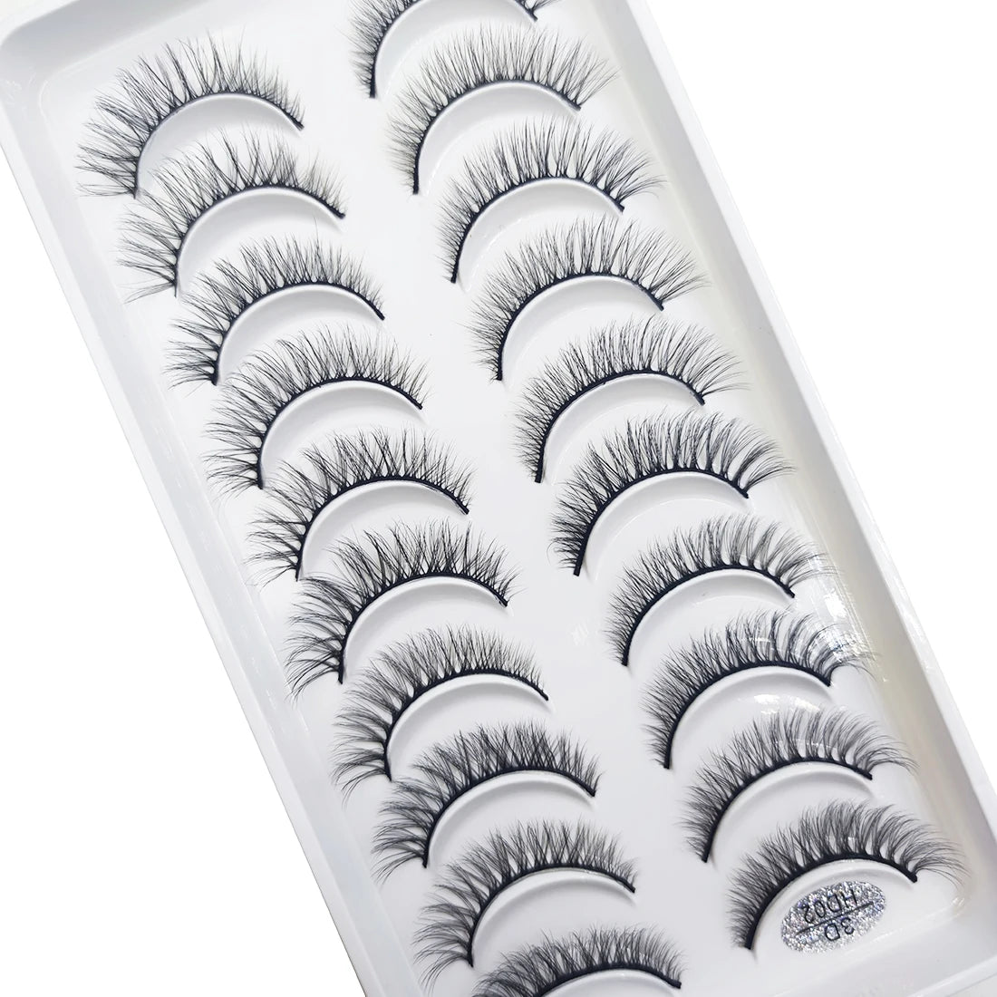 A tray of natural 3D mink false eyelashes displayed in a white plastic container.