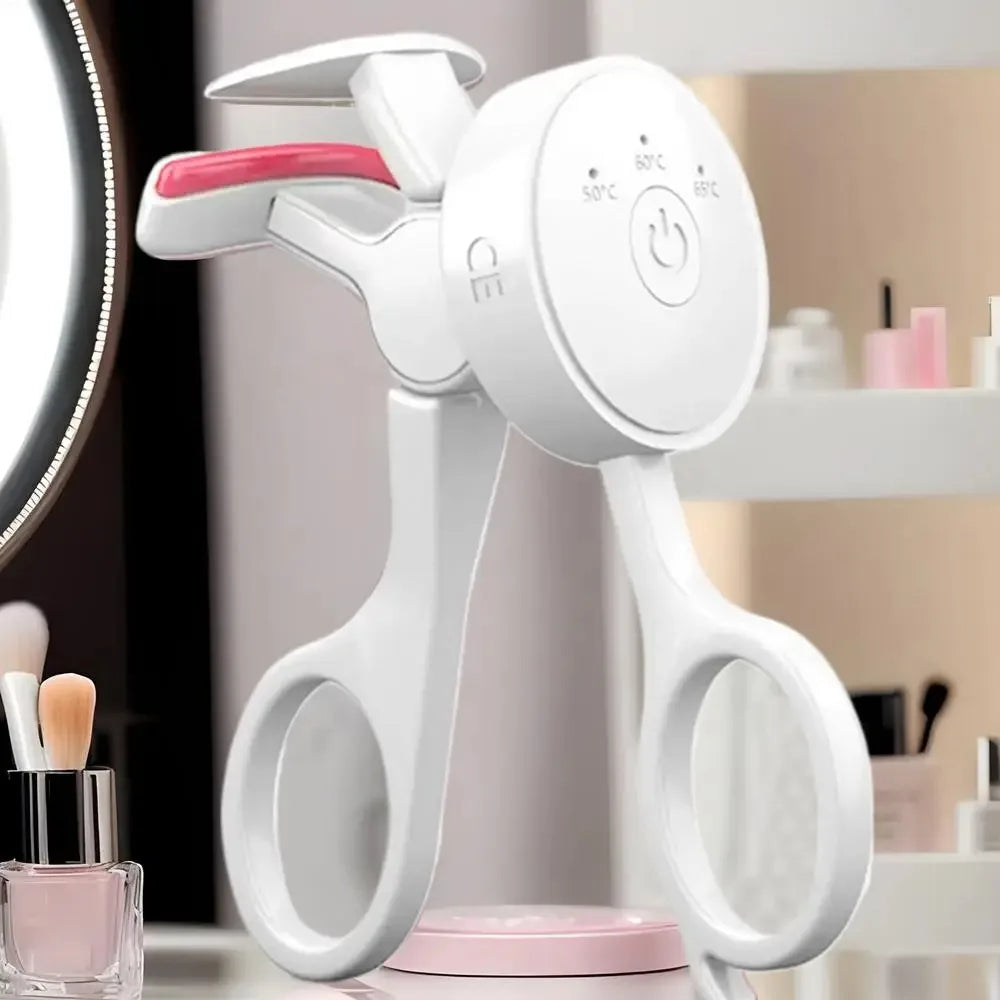 A white frameless heated eyelash curler with temperature control is shown on a surface.