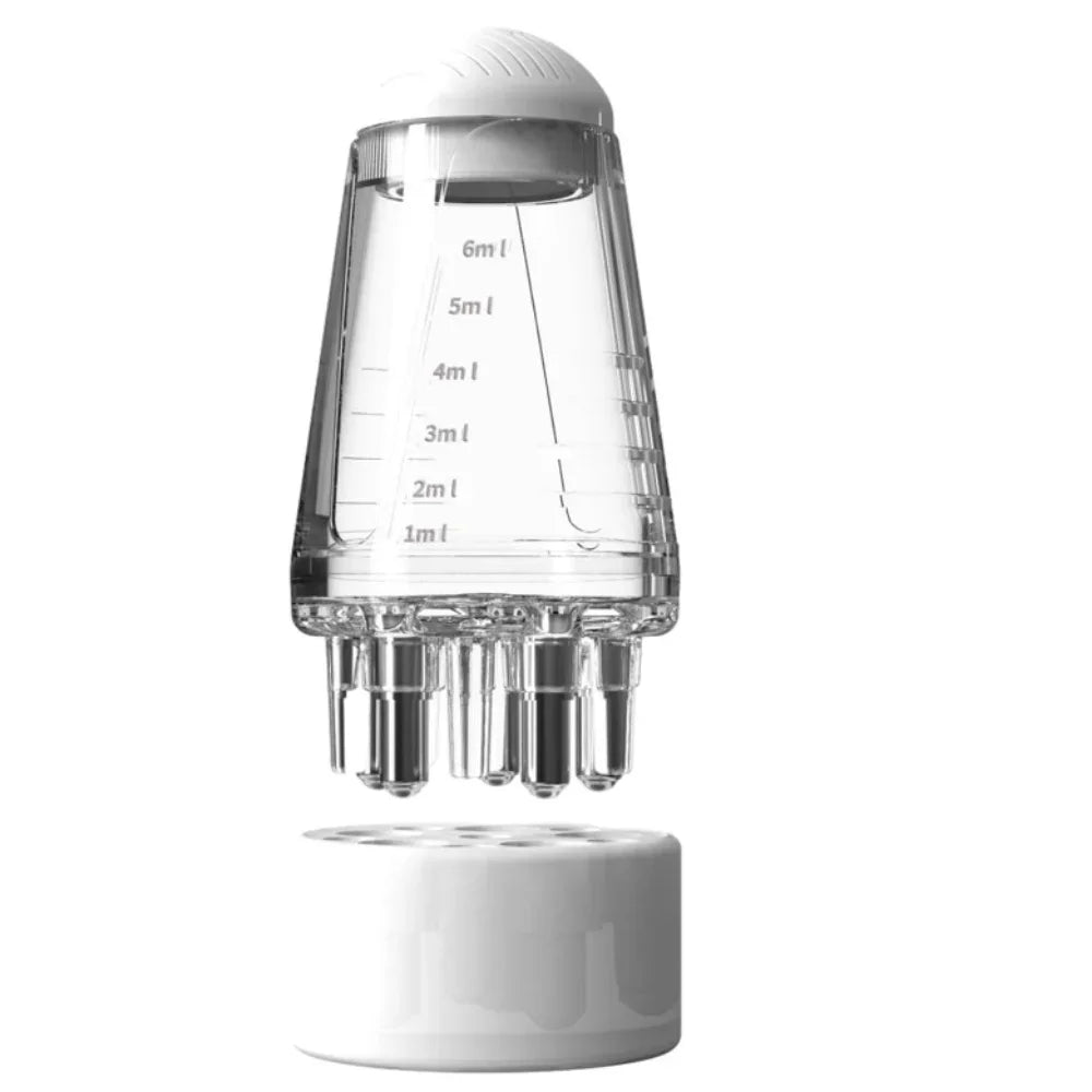 A clear precision scalp oil applicator bottle with a ball-tip massager and volume markings.