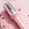 A pink automatic hair ends trimmer is shown resting on a pink circular surface.