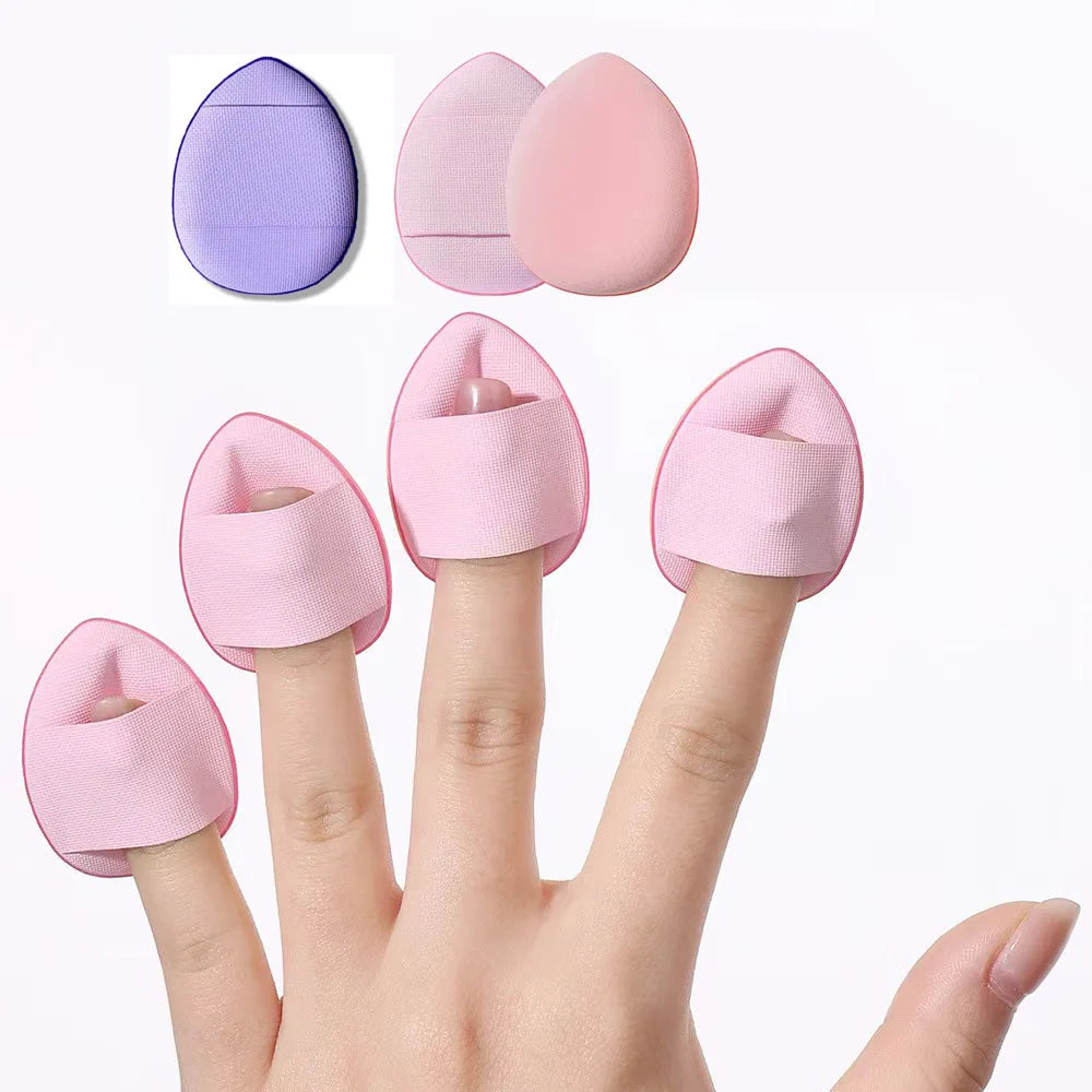 A hand is shown holding pink mini finger puff foundation applicator tools, with color options visible.