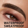 Close-up of a woman's eye showing a dark eyebrow pencil applied to the brow area.