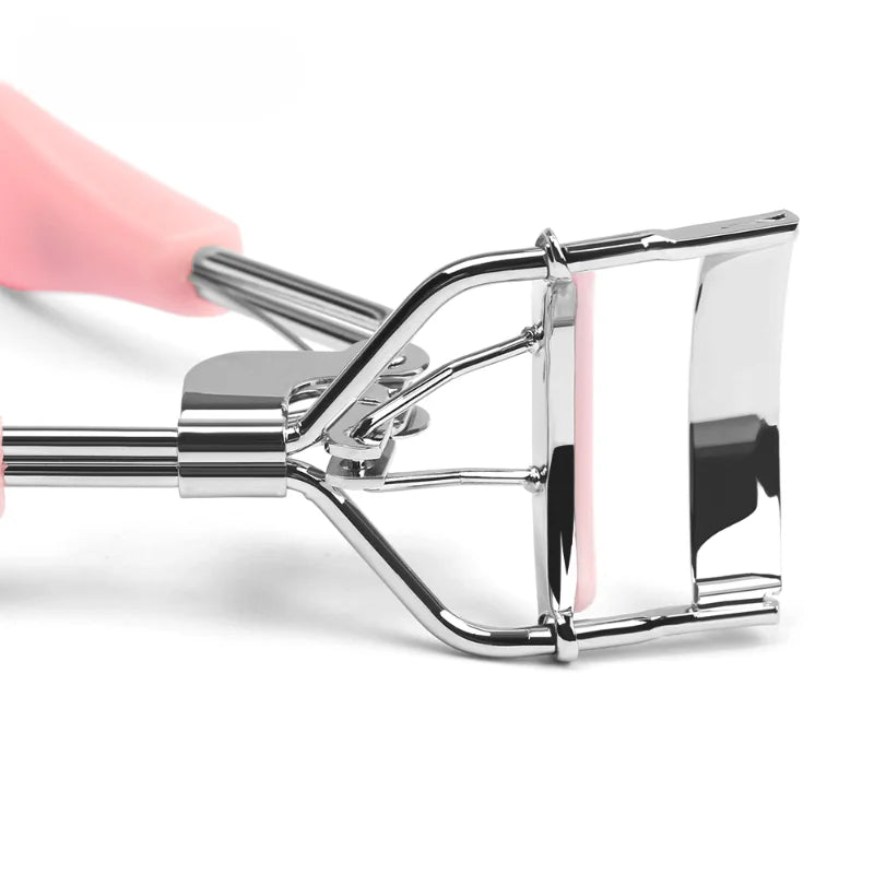 A silver eyelash curler with a pink handle is shown in a close-up view.
