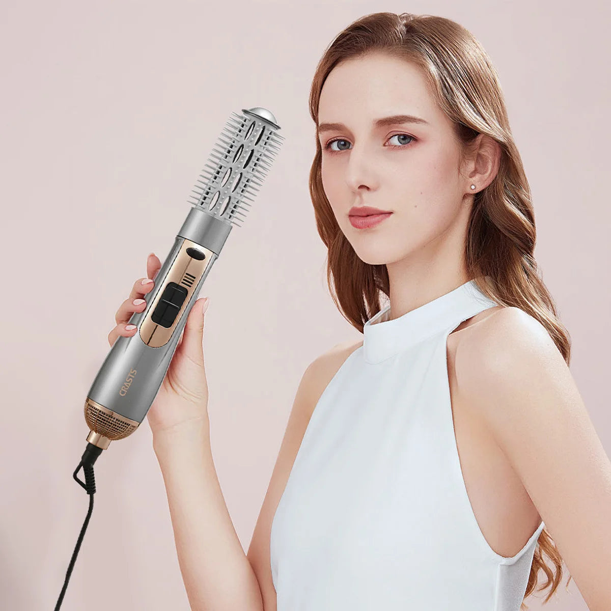 A woman holds a silver hot air styling comb for blow-dry, straightening, and curling.