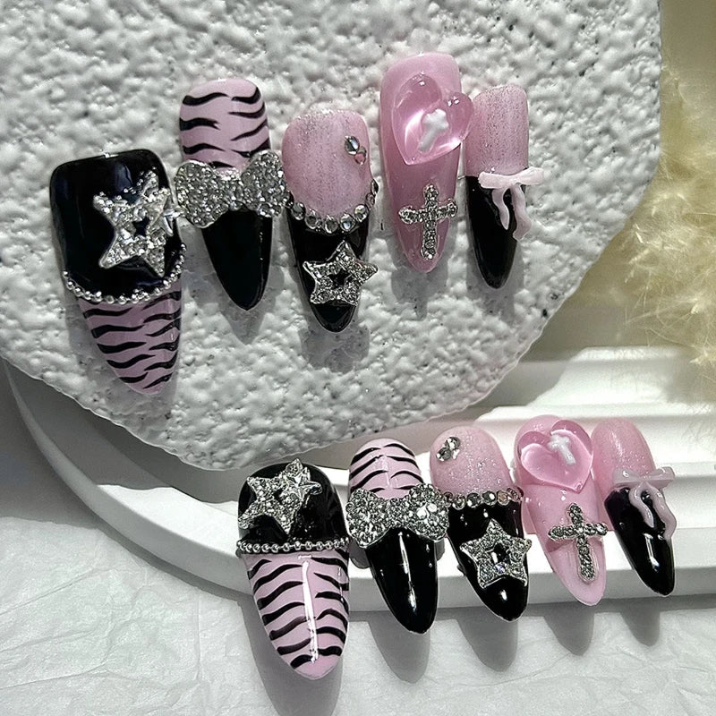 A set of glitter diamond press on nails featuring black, pink, and zebra print designs.