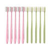 A set of ten pink and light green ultimate deep cleaning toothbrushes arranged in a row.